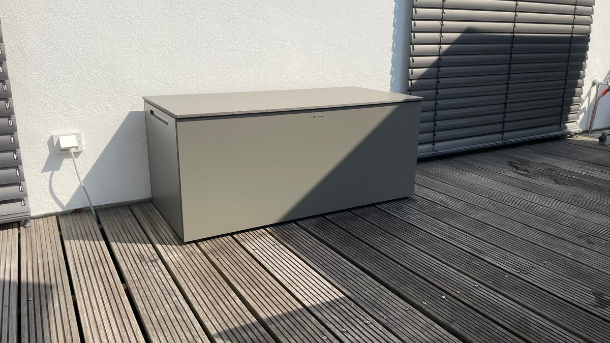 Graue BOXA Kissenbox aus HPL als wetterfeste Gartenbox auf einer Terrasse